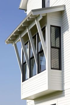 a white house with three windows on the top floor and one window in the middle