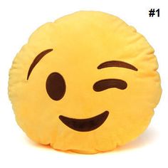 a yellow smiley face pillow sitting on top of a white table