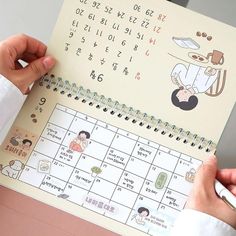 a person is holding a calendar in their hands