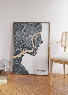 a framed map of philadelphia, pennsylvania on the floor next to a chair and lamp