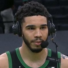 a man with headphones on wearing a basketball uniform