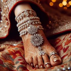 a woman's feet covered in hennap and bracelets with jewels on them