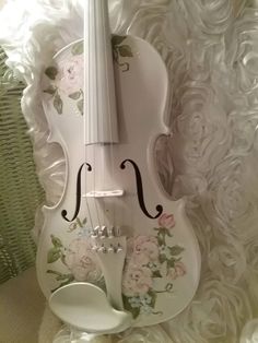 a white violin with flowers painted on it