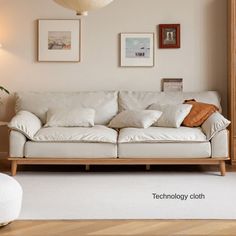 a white couch sitting in a living room on top of a hard wood floored floor