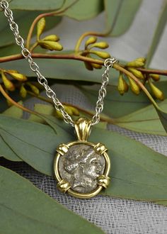 a gold and silver necklace with an image of a man's face on it