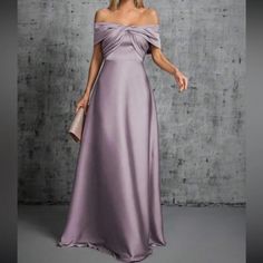 a woman in a long purple dress posing for the camera with her hand on her hip