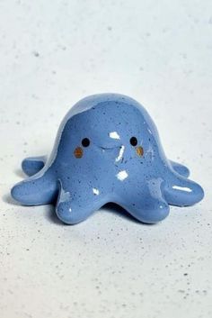 a blue ceramic figurine sitting on top of a white counter with speckles