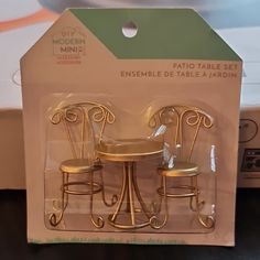 two miniature chairs and table set in plastic packaging