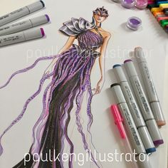 some markers and crayons are on the table next to a drawing of a woman in a purple dress