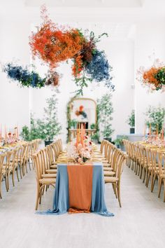 the tables are set up with blue and orange linens for an elegant wedding reception