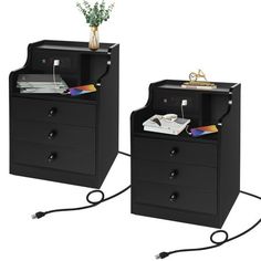 two black filing cabinets with drawers and wires connected to each other, one has a plant on top