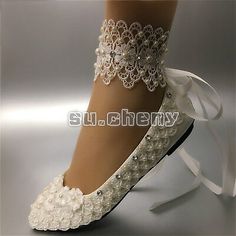 white bridal shoes with lace and pearls on the heel, decorated with beads and bows