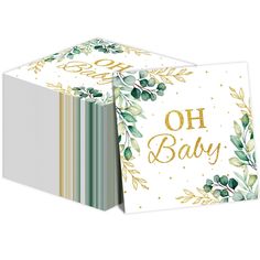 a folded card with the words oh baby written on it and gold foil lettering, surrounded by green leaves