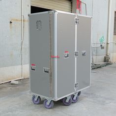 a large metal box sitting on wheels in front of a building