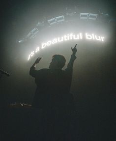 a man standing in front of a stage with his hands up and the words it's a beautiful day written on it