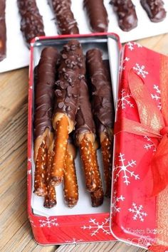 chocolate covered pretzels are in a red box with a bow on the side