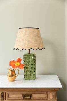 a table with a lamp and vase on it