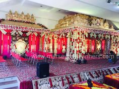 an elaborate stage set up with red and gold decor for a wedding ceremony in india