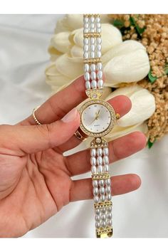 Discover the elegance of our Inspired Pearl Vintage Watch, a stunning timepiece that beautifully combines classic charm with modern sophistication. This women's vintage watch is perfect for any occasion, whether you're dressing up for a special event or adding a touch of glamour to your everyday look. Key Features: Vintage Design: Embrace timeless style with a vintage watch that features an exquisite pearl band, adding a touch of luxury to your wrist. Minimal Round Dial: The watch boasts a minimal round dial for a sleek and sophisticated appearance, making it a versatile accessory for any outfit. Embedded Zircon Stone: Delicate zircon stones are embedded for a subtle sparkle, enhancing the overall elegance of this pearl watch. Cord Length: With an average cord length of 18 cm, this watch i Vintage Handmade Watches For Formal Occasions, Vintage Dainty Watch, Dainty Gold Watch Vintage, Pearl Watches Women, Delicate Pearl Jewelry, Dainty Watch, Pearl Watch, Elegant Self-winding Collectible Watch, Pearl Jewelry Gift