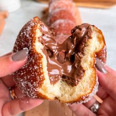 chocolate covered doughnuts in a basket with powdered sugar