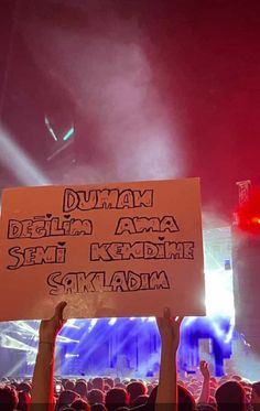 a person holding up a sign at a concert