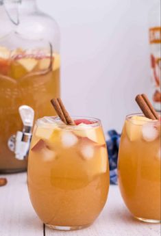 two glasses filled with apple cider and cinnamon stick garnish on the side