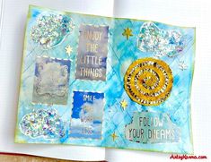 A finished mixed media journal page with an embossed texture, featuring inspirational quotes, metallic stars, and a glittery spiral.