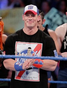 a man standing in front of a wrestling ring with his hands clasped to each other