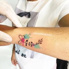 a person getting a tattoo on their arm with hearts and arrows in the shape of birds