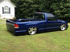 a blue pick up truck parked in the grass