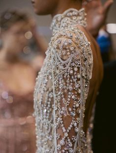 the back of a woman's dress with beading on it