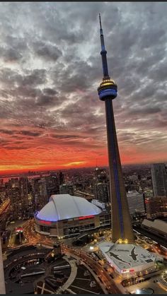 an aerial view of the sky tower at dusk with clouds and buildings in the background