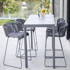 the table and chairs are set up outside on the concrete floored patio with glass doors