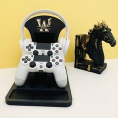 a game controller sitting on top of a table next to a black horse head statue