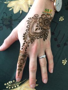 a woman's hand with henna tattoos on it