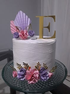 a white cake with pink and purple flowers on it