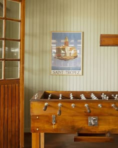 an old fashioned foosball in a room with green walls and wood trimming