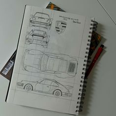 an open notebook with drawings of cars on it