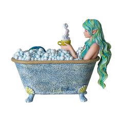 a figurine sitting in a bathtub filled with blue balls and holding a cup