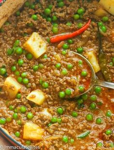 a bowl filled with meat and peas on top of a table