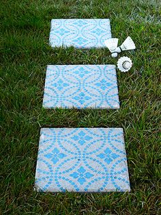 three blue and white tiles laying on the grass