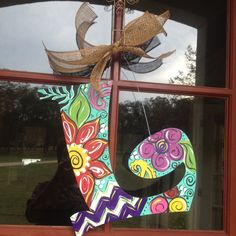 a decorated letter hanging from the side of a window