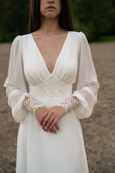 a woman in a white dress is posing for the camera with her hands on her hips