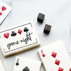 some cookies that are on top of a table with playing cards and dices next to them