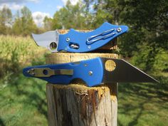 a pair of blue scissors sitting on top of a wooden post