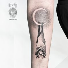 a person with a tattoo on their arm and the moon above them is holding an object