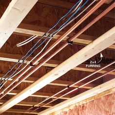 some wires are hanging from the ceiling in an unfinished room that is being built with plywood