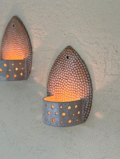 two metal wall sconces with orange lights on them