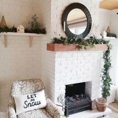 a living room with a white brick fireplace and christmas decorations on the mantel above it