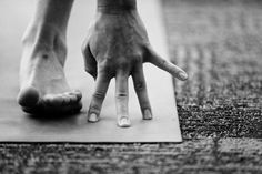 a person standing on top of a yoga mat with their hands in front of them